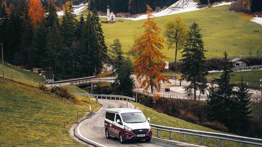 Campervan driving along a winding road in the mountains