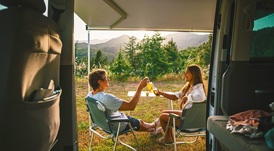 couple enjoying a drink in front of a campervan