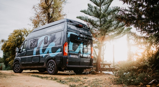Grey Fiat Ducato camper parked at a campsite with