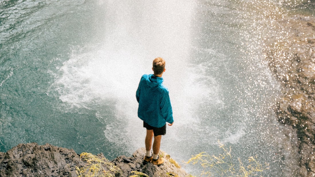 hiker lokking at a waterfall