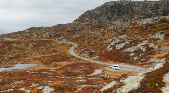 white campervan next to a road in the mountains