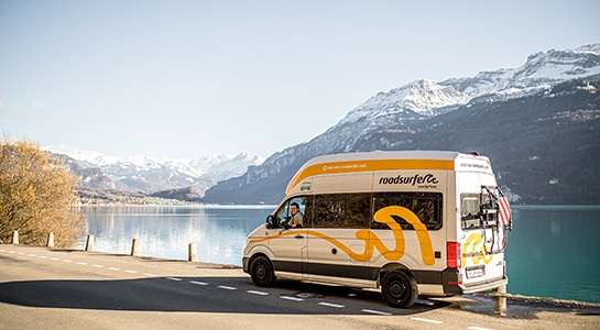 white motorhome next to a lake