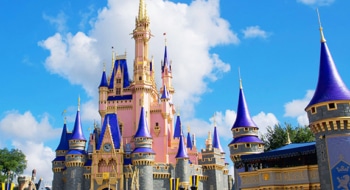 Pink Walt Disney World Castle seen on a sunny day.